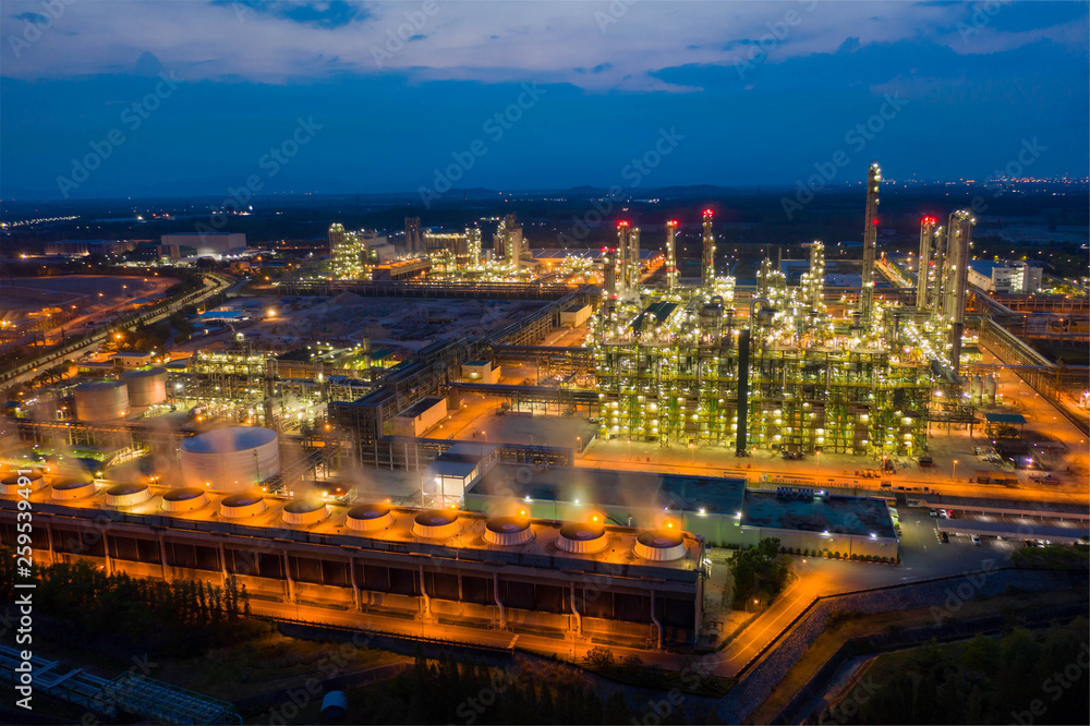 Aerial view. Oil refinery factory and oil storage tank at twilight and night. Petrochemical Industrial