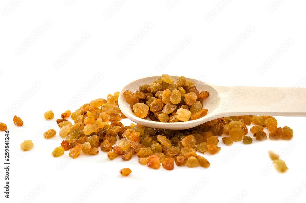 yellow raisin and wooden spoon on a white background yellow raisin and wooden spoon on a white background