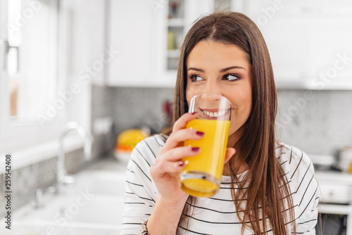 Close up of teenage girl drinking juice while looking through a window