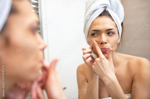 Young girl getting rid of the pimple