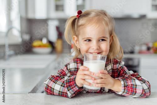 Girl with milk mustache after drinking milk from a glass.