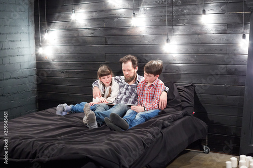evening family reading. father reads children a book before going to bed