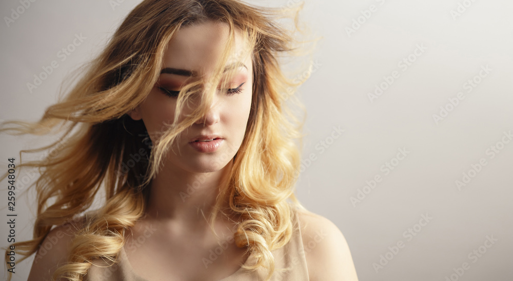 soft studio portrait of a beautiful young woman, girl face with curly hair disheveled from wind , the concept of natural beauty, body care, cosmetics soft studio portrait of a beautiful young woman, girl face with curly hair disheveled from wind , the concept of natural beauty, body care, cosmetics