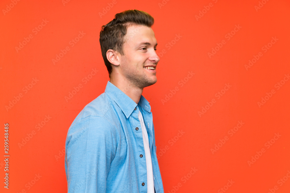 Blonde handsome man over isolated wall standing and looking to the side Blonde handsome man over isolated wall standing and looking to the side