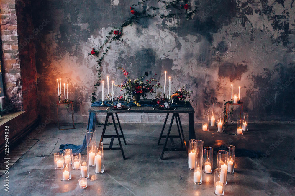 burning candles with bouquets of flowers on the table