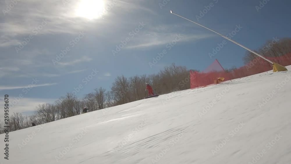 Snowboarder going down steep trail at ski resort Snowboarder going down steep trail at ski resort