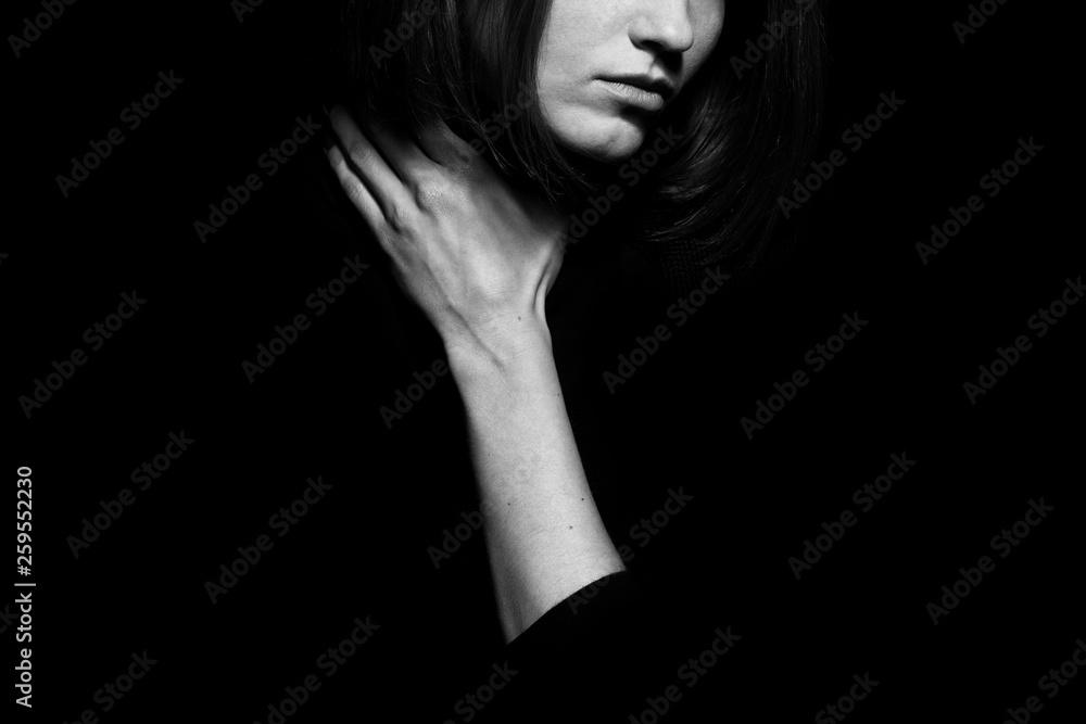 #metoo movement concept. Closeup portrait of young woman hiding face, posing with hand on neck, isolated on black background. Human emotion, expression, rights & communication. Text space. Monochrome #metoo movement concept. Closeup portrait of young woman hiding face, posing with hand on neck, isolated on black background. Human emotion, expression, rights & communication. Text space. Monochrome