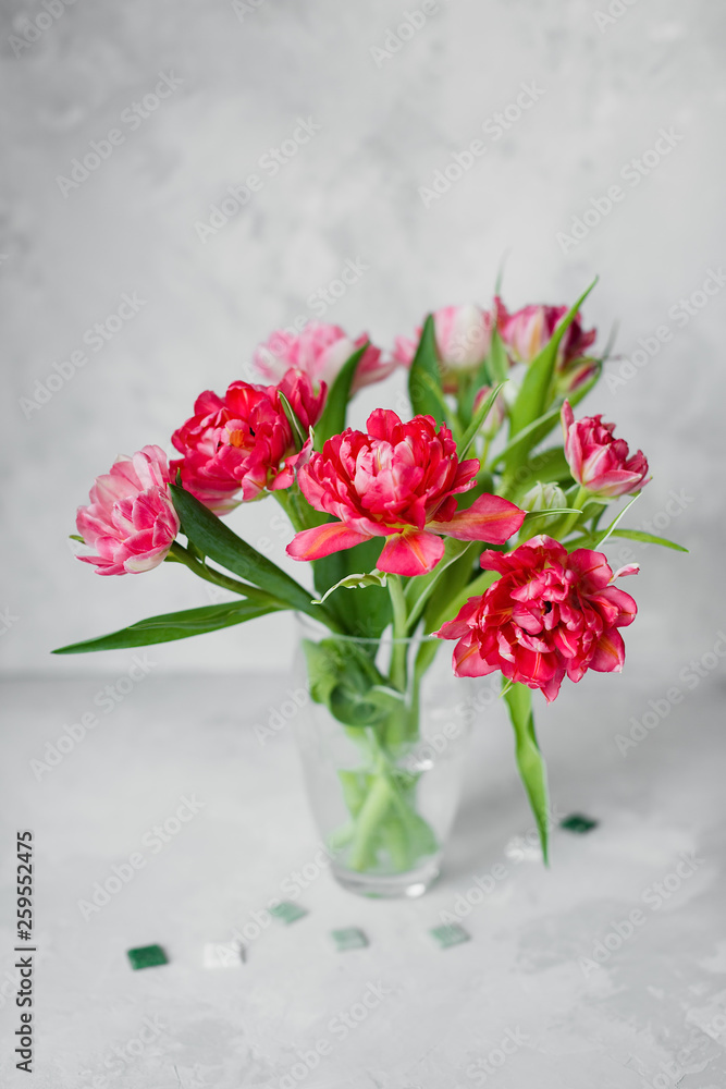 Vase with tulip flowers ,paintbrush with color on a canvas painting and mosaic on gray backround. Vase with tulip flowers ,paintbrush with color on a canvas painting and mosaic on gray backround.
