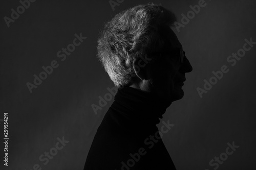 Wallpaper Mural Movie poster, book cover, film noir concept. Arty profile portrait of fashionable mature man wearing trendy black turtleneck. Silver hair. German expressionism style. Contrastive monochrome shot Torontodigital.ca