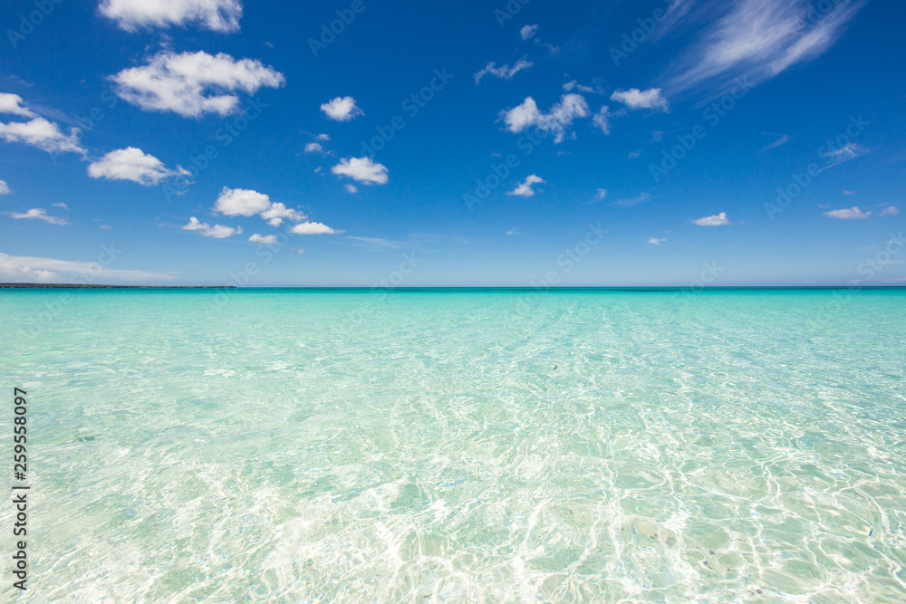 Horizon line with crystal clear water of the Caribbean Sea and blue sky with clouds. Calm and relaxation. Beautiful background. Dominican Republic, Barahona Bahia de las Aguilas. Best beaches 