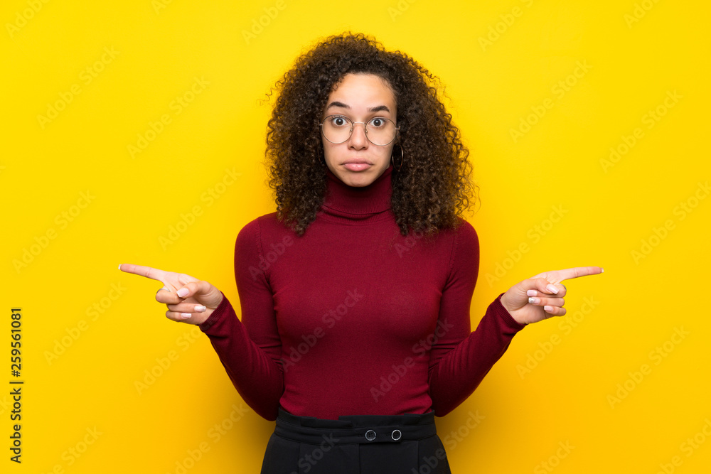 Dominican woman with turtleneck sweater pointing to the laterals having doubts Dominican woman with turtleneck sweater pointing to the laterals having doubts