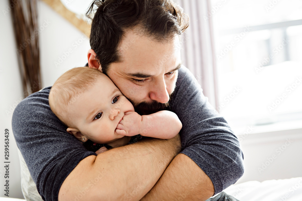 Fototapeta premium A Nice and protect father with baby on bed