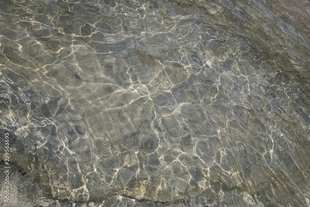 Water sun reflection of rock and sand background Water sun reflection of rock and sand background
