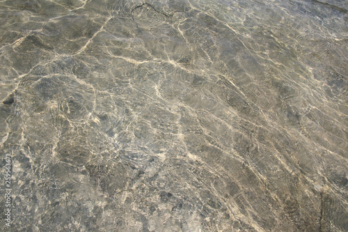 Water sun reflection of rock and sand texture