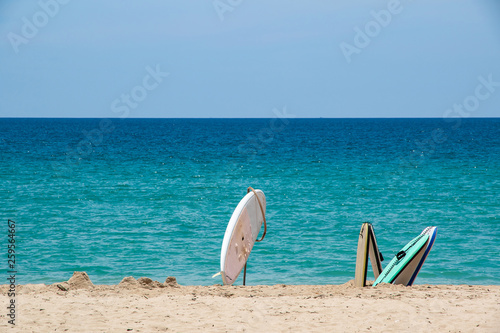 Three old surfboard on the sand beach.
