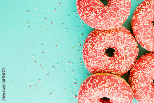 Donuts decorated with icing on blue background.