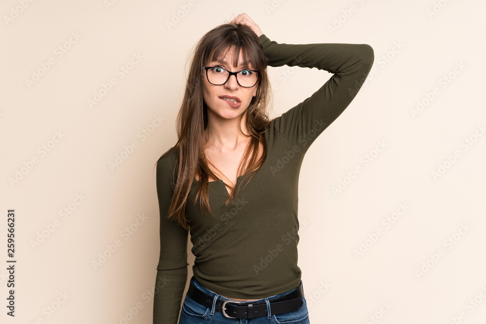 Young woman on ocher background with confuse face expression Young woman on ocher background with confuse face expression