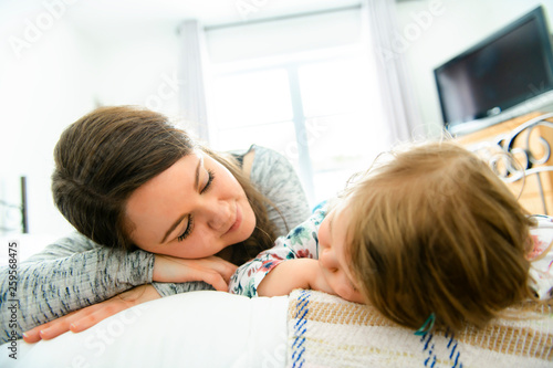 A Mother and daughter enjoy in bed at home