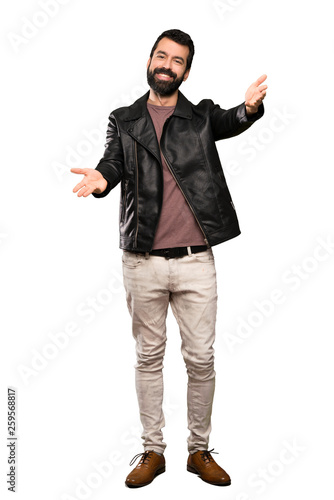 Handsome man with beard presenting and inviting to come with hand over isolated white background © luismolinero