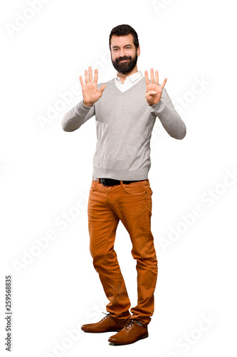 Handsome man counting nine with fingers over isolated white background © luismolinero