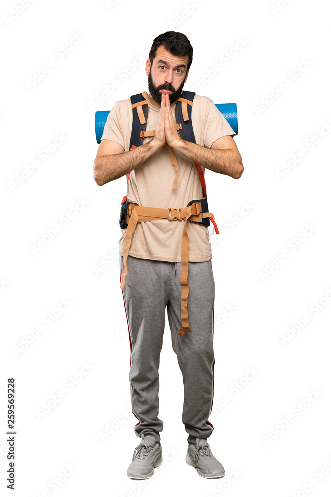 Hiker man keeps palm together. Person asks for something over isolated white background Hiker man keeps palm together. Person asks for something over isolated white background