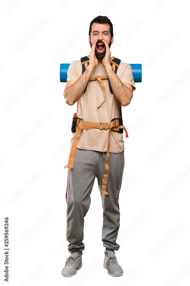Hiker man shouting and announcing something over isolated white background Hiker man shouting and announcing something over isolated white background