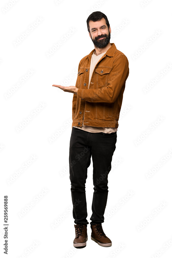 Handsome man with beard presenting an idea while looking smiling towards over isolated white background Handsome man with beard presenting an idea while looking smiling towards over isolated white background