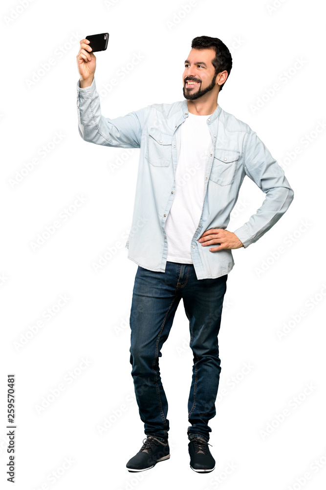 Full-length shot of Handsome man with beard making a selfie over isolated white background Full-length shot of Handsome man with beard making a selfie over isolated white background