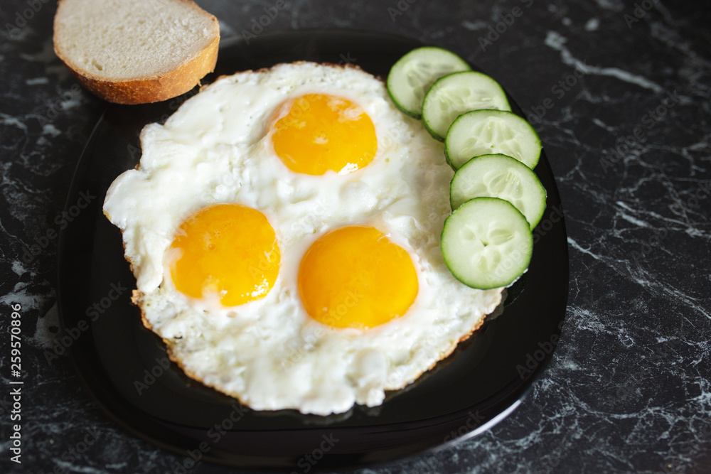 Breakfast. Fried eggs with bread and cucumbers Breakfast. Fried eggs with bread and cucumbers