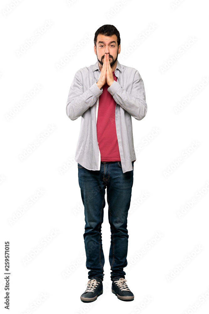 Full-length shot of Handsome man with beard keeps palm together. Person asks for something over isolated white background Full-length shot of Handsome man with beard keeps palm together. Person asks for something over isolated white background