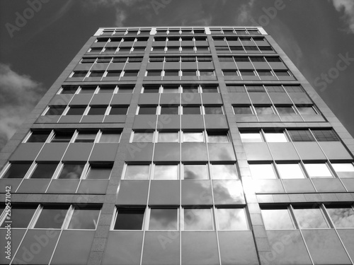 Spiegelnde Fenster und Fassade eines älteren Hochhaus im Sonnenschein an der Hamburger Allee im Stadtteil Bockenheim in Frankfurt am Main in Hessen, fotografiert in klassischem Schwarzweiß photo