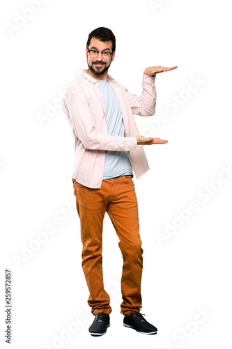 Full-length shot of Handsome man with beard holding copyspace to insert an ad over isolated white background
