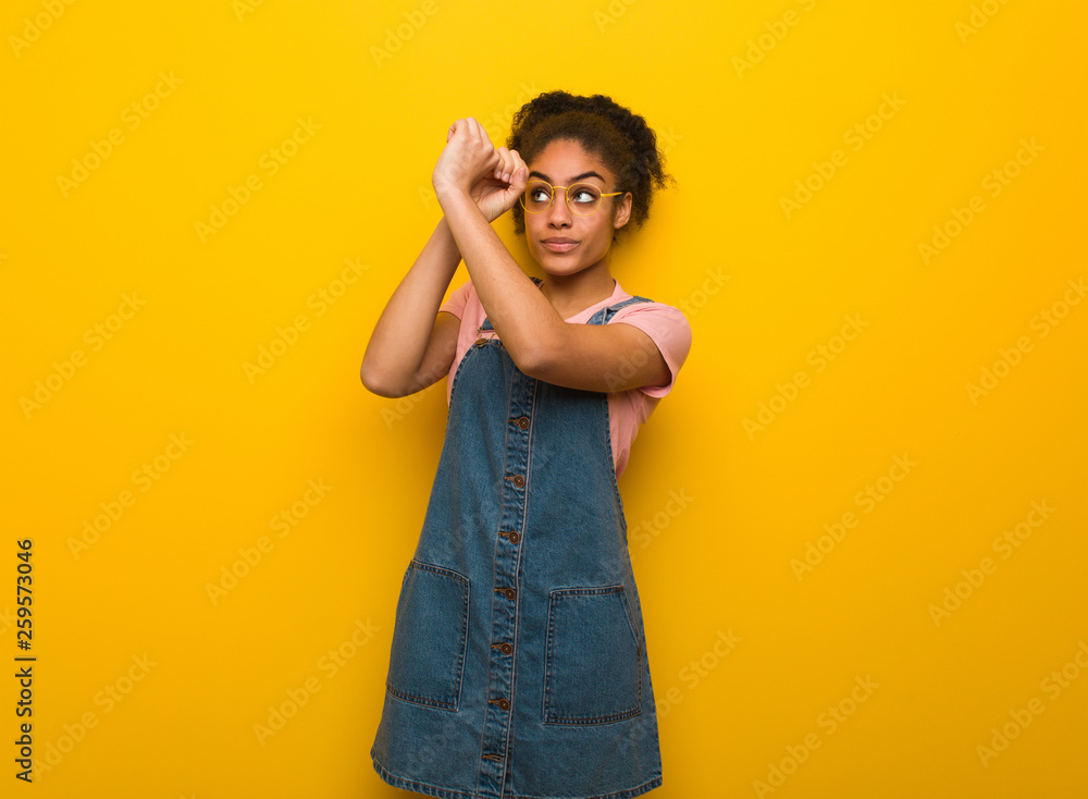 Young black african american girl with blue eyes making the gesture of a spyglass Young black african american girl with blue eyes making the gesture of a spyglass