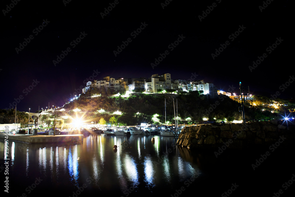 Stars, night and light on Sperlonga, Lazio. Italy. View from sea on the harbour and skyline.