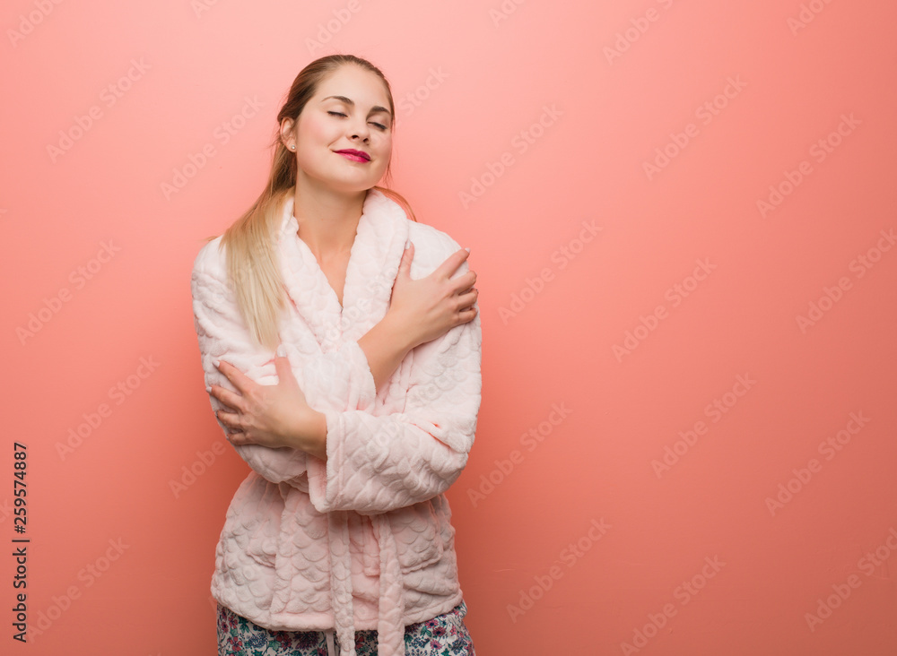Obraz premium Young russian woman wearing pajama giving a hug