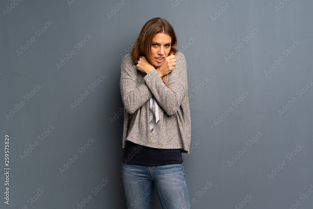 Blonde woman over grey background freezing Blonde woman over grey background freezing