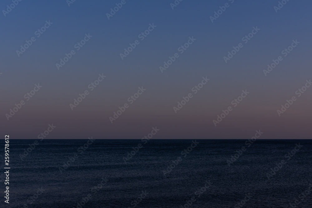 Quiet cozy evening at sea, purple sunset on the sea coast