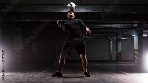 A young soccer man training the basic tricks with the ball Balancing the ball on the head