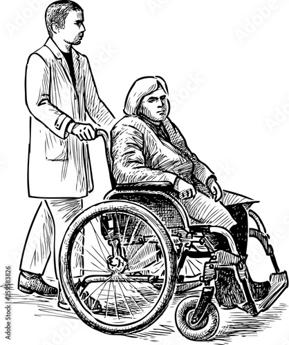 An old woman in a wheelchair with her nurse