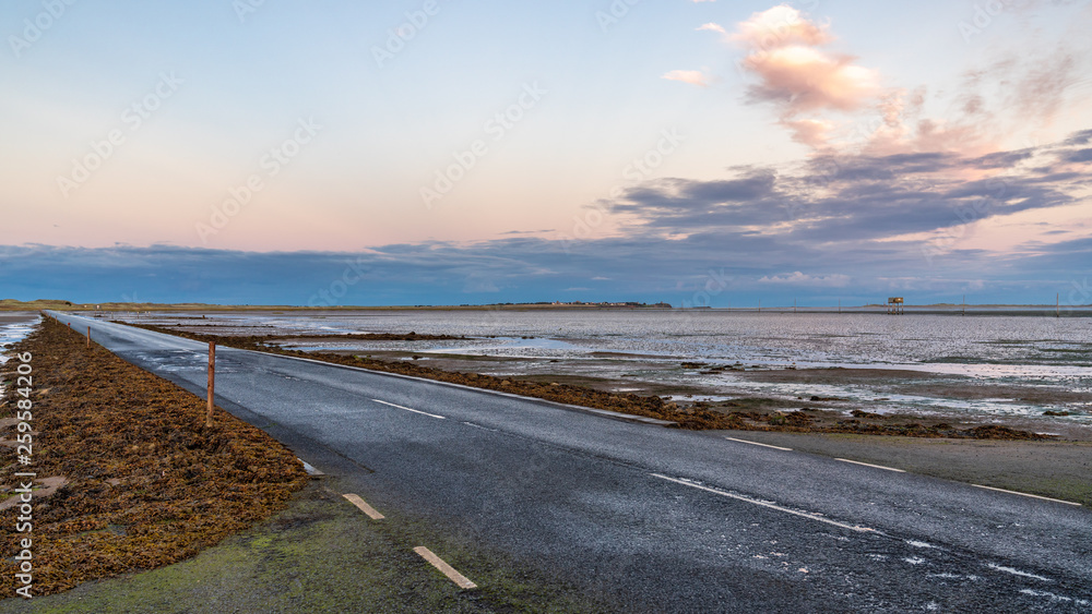 Evening sky and low tide on the road  between Beal and Holy Island, Northumberland, England, UK