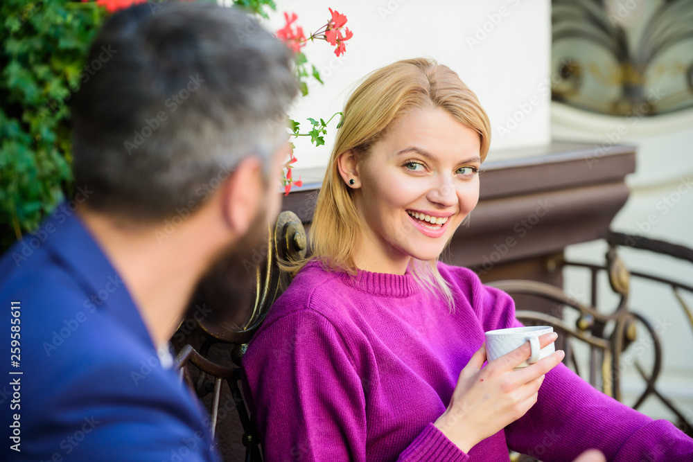 woman and man with beard relax in cafe. First meet of girl and mature man. Morning coffee. Couple in love on romantic date. Brutal bearded hipster and girl drink coffee. What a great morning