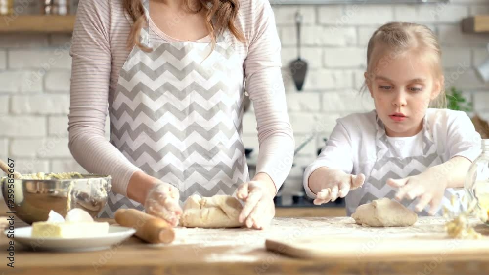 Mother and daughter cooking together. Preparing dough. Mother and daughter cooking together. Preparing dough.