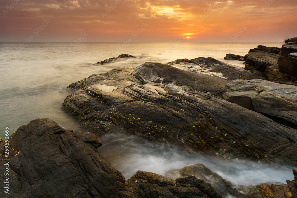 Beautiful natural seascape wave hit the rock during sunset