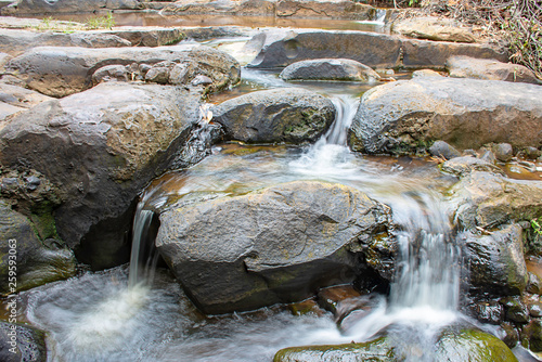 The water flowing over rocks and trees down a waterfall at Khao Ito waterfall , Prachin Buri in Thailand. photo