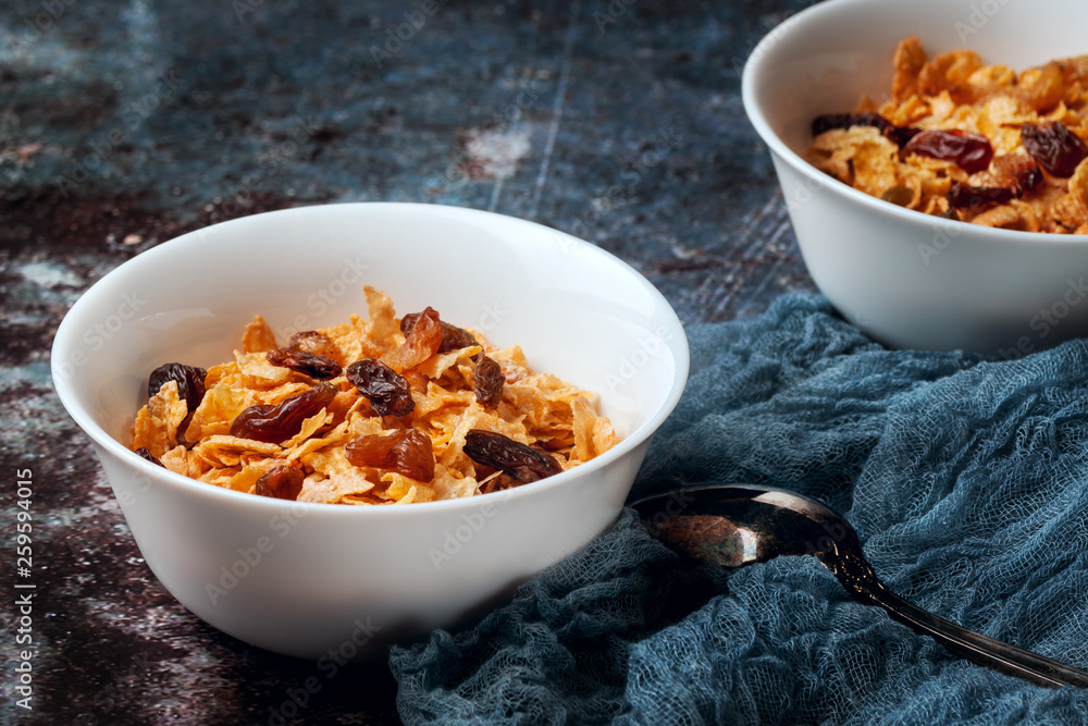 Bowl with cornflakes on a dark gray background Bowl with cornflakes on a dark gray background