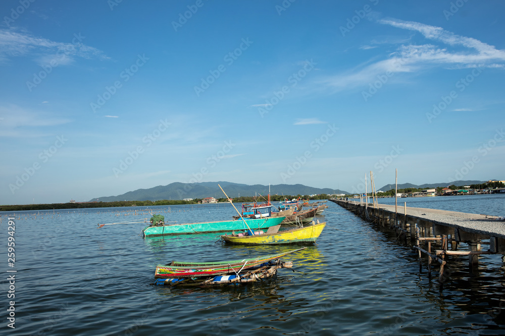 old fishing harbor in Chonburi province , Thailand , Fishing harbor backdrop blue sky and green mountain