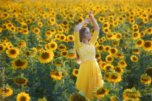 Young beautiful girl in a field of sunflowers