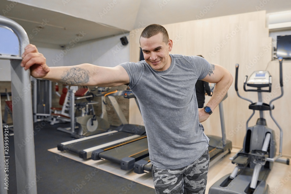 Portrait of young smiling strong muscular man in the gym Portrait of young smiling strong muscular man in the gym