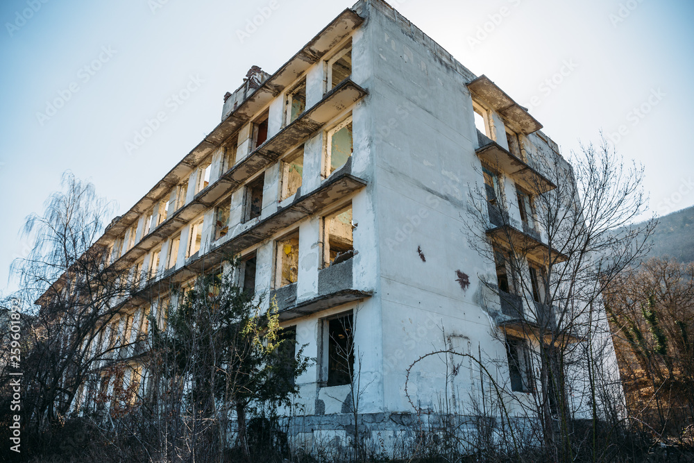 Fototapeta premium Not finished abandoned ruined European building, empty windows and concrete walls