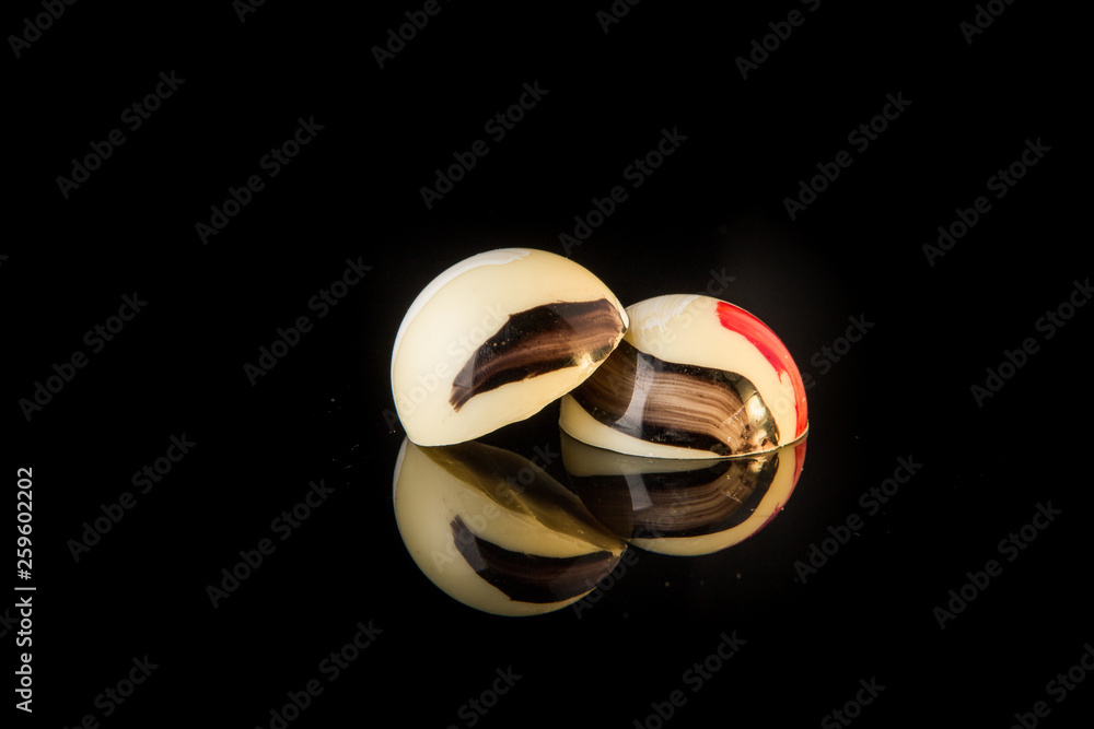 closeup two round shaped colorful chocolate candies with reflection closeup two round shaped colorful chocolate candies with reflection